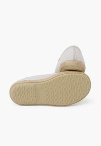 Scarpe slip-on in tela con tomaia beige, rifinitura in juta naturale e suola in gomma testurizzata con un motivo a onde.