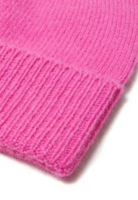 Cappello di lana rosa a maglia con una trama a costine, dotato di un risvolto pieghevole. Il materiale sembra morbido e peloso, evidenziando un colore vivace.