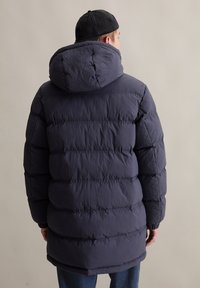 Dunkelblauer Puffer-Jacke mit Kapuze, gestepptem Design, elastischen Bündchen und bequemer Passform. Hergestellt aus einem leichten, strukturierten Stoff.