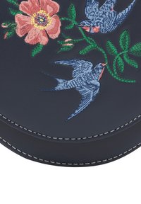 Marineblaue Leder- Tasche mit detaillierter Stickerei von rosa Blumen und blauen Schwalben. Verfügt über weißen Stich entlang der Kanten.