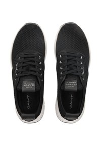 Czarne sportowe buty z teksturowaną siateczką, białe podeszwy, okrągłe sznurówki i metka z logo na języku. Prosty design z minimalnymi akcentami.