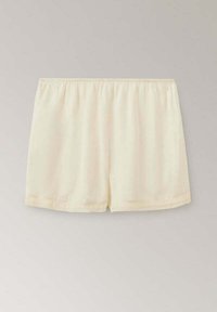 Shorts amples couleur crème avec une taille élastique, affichés sur un fond gris clair.