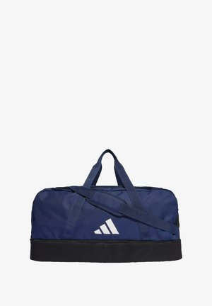 Bolsa de deporte azul marino hecha de tela duradera con acentos negros. Cuenta con dos asas, una correa para el hombro y un logo blanco en el lateral.