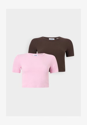 To ribbestrikkede korte topper med korte ermer i rosa og brunt, stablet opp mot en ensfarget lys bakgrunn.