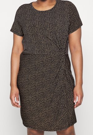 Short-sleeve black dress with beige irregular dot pattern, ruched detail on right side, worn by a person with medium skin tone.