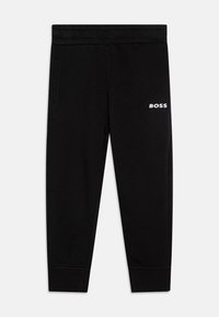 Schwarze Jogginghosen aus weichem Stoff, mit einem elastischen Bund, seitlichen Taschen und einem weißen "BOSS"-Logo am linken Oberschenkel.