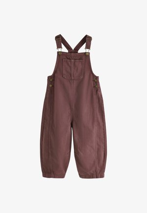 Bruine overall met wijde pijpen, verstelbare schouderbanden en een voorzak op de borst, knoopsluitingen aan de zijkanten en elastische boorden.