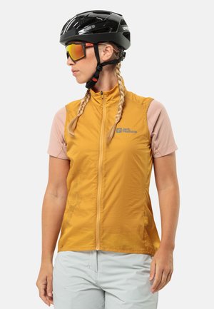 Gele fietsvest met ritssluiting, lichtgewicht stof en een logo op de borst; gecombineerd met een lichtroze shirt met korte mouwen en een helm.