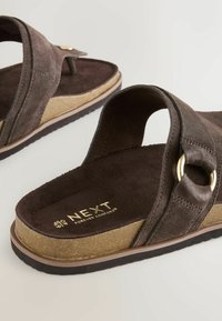Sandales en daim marron avec boucle dorée, semelle compensée en liège et étiquette « NEXT Forever Comfort » sur la semelle intérieure.
