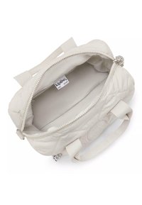 Quiltowana kremowa torebka z dwoma krótkimi uchwytami, zapięciem na zamek i gładką podszewką wewnętrzną. Zawiera metkę z logo "Kipling".
