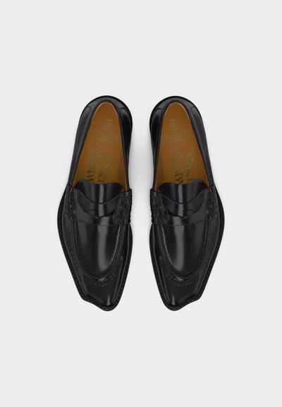 Čierne leštené kožené mokasíny so špicatými špičkami a prešívanými detailmi, pohľad zhora na bielom pozadí.