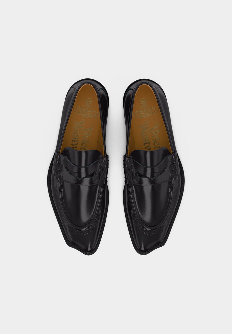 Mocassins en cuir noir verni avec bouts pointus et détails cousus, vus de dessus sur un fond blanc.