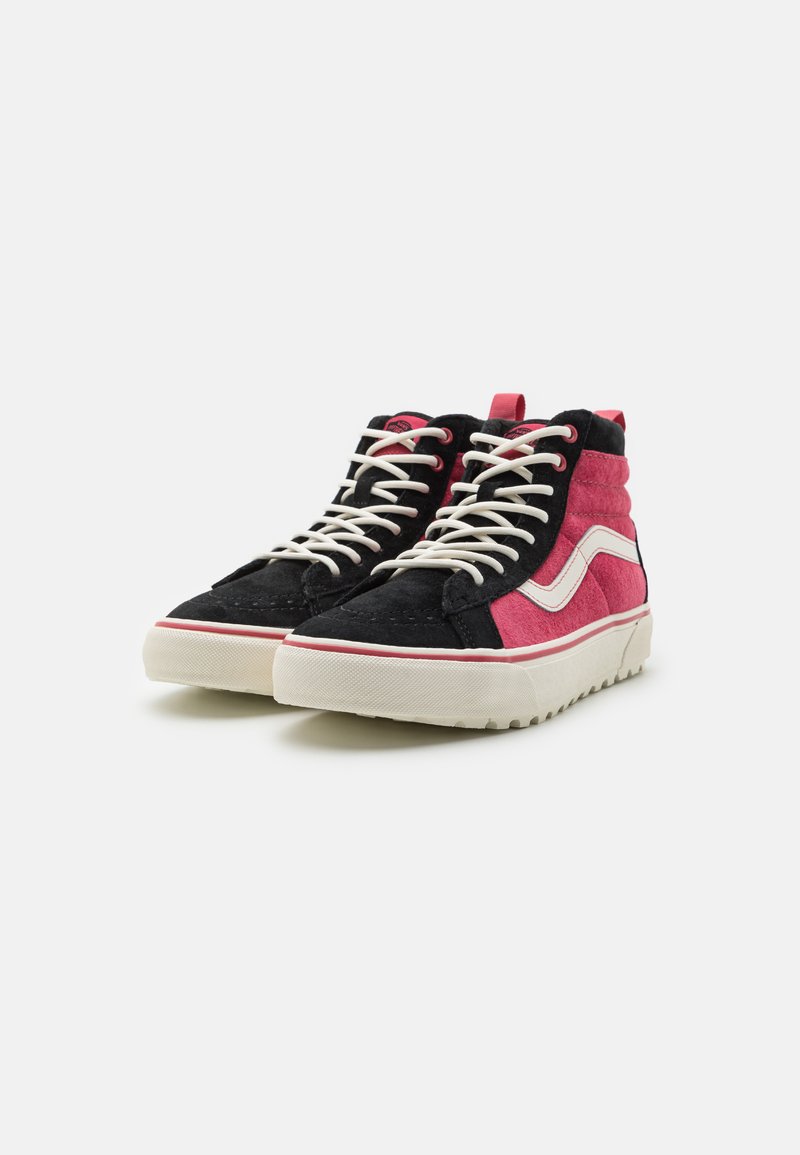 Zapatillas altas con paneles de ante negro y rosa, raya lateral blanca, cordones blancos, suelas gruesas blancas con goma texturizada, vista lateral frontal.