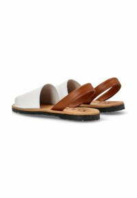 Sandalias de cuero blanco con una correa de cuero marrón, diseño abierto, plantilla de corcho natural y suela de goma negra.