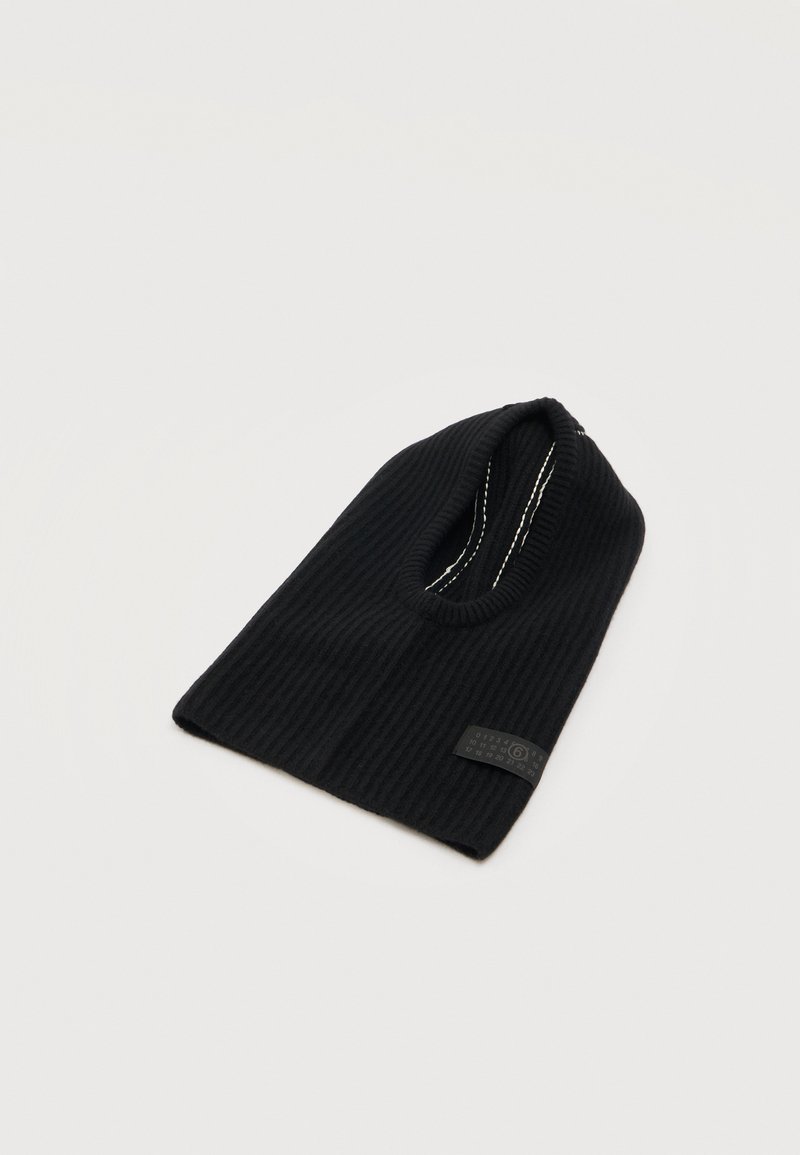 Cagoule noire en maille côtelée avec une ouverture circulaire pour les yeux et une petite étiquette rectangulaire sur le côté inférieur.