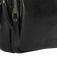 Borsa a tracolla in pelle nera con finitura testurizzata, dotata di una cerniera con hardware in metallo e logo del marchio impresso sul lato.