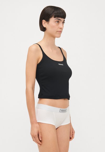 Zwarte getailleerde tanktop met een ronde hals; witte boyshorts met een grijze tailleband. Beide hebben een logotag aan de voorkant.