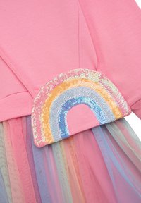 Rotes Baumwollkleid mit einem Pailletten-Regenbogenapplikation in Gelb, Blau und Lila; geschichteter pastellfarbener Tüllrock.