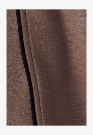 Bruine stof met een gladde textuur, voorzien van een zwarte naadaccent aan één kant voor detail. De stof toont lichte rek en flexibiliteit.