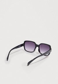 Μαύρα γυαλιά ηλίου με τετράγωνους σκελετούς, φακούς με βαθμιαία απόχρωση σκούρου μωβ και λεία πλαστική κορνίζα. Περιλαμβάνει λογότυπο στο εσωτερικό μέρος του μπράτσου.