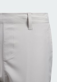 Lichtgrijze stoffen broek met een gladde textuur, ceintuurlussen, een voorzak en gestikte details langs de naden.