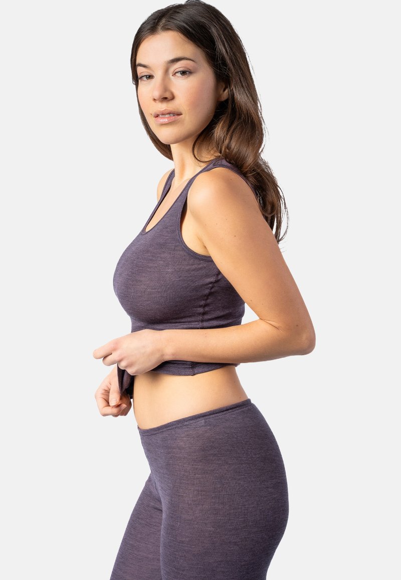 Lila gerippte Cropped-Top kombiniert mit passenden hoch taillierten Leggings. Weicher Stoff und taillierte Passform, mit breiten Schulterträgern und einem Midriff-Ausschnitt.