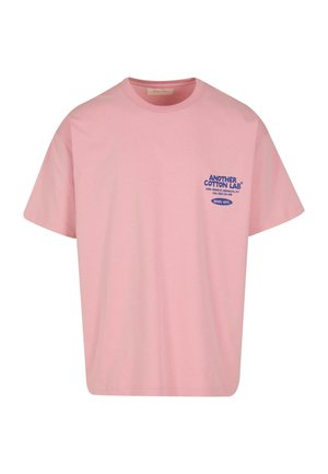 Pink cotton t-shirt with short sleeves, featuring blue text "ANOTHER COTTON LAB" and accompanying label on the left chest area.