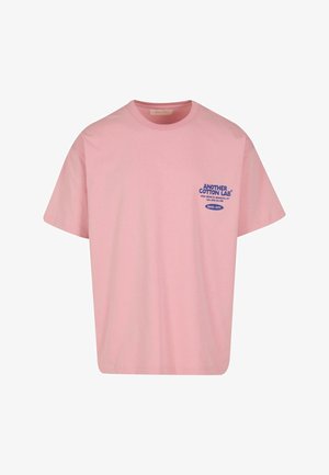 T-shirt di cotone rosa con maniche corte, con testo blu "ANOTHER COTTON LAB" e etichetta supplementare nell'area sinistra del petto.