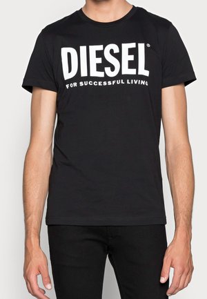 T-shirt en coton noir avec un col rond, ornée d'un lettrage blanc audacieux "DIESEL" et de "POUR UNE VIE RÉUSSIE" imprimé en dessous. Manches courtes.