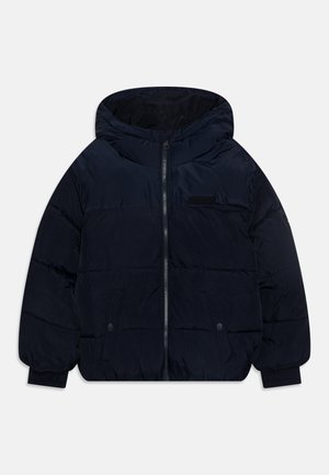 Chaqueta tipo puffer en color navy con capucha, cierre frontal, dos bolsillos laterales, puños de canalé y diseño acolchado, fabricada en un tejido ligero y texturizado.