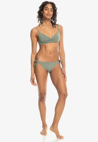 Olijfgroen bikini set met een wikkeltop met dunne bandjes en bijpassende lage slipjes met verstelbare zijbandjes. Soepele textuur.