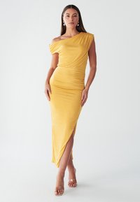 Robe jaune décolletée, fluide avec des détails drapés, silhouette ajustée, fente latérale et ourlet à la cheville. Texture lisse, design minimaliste.