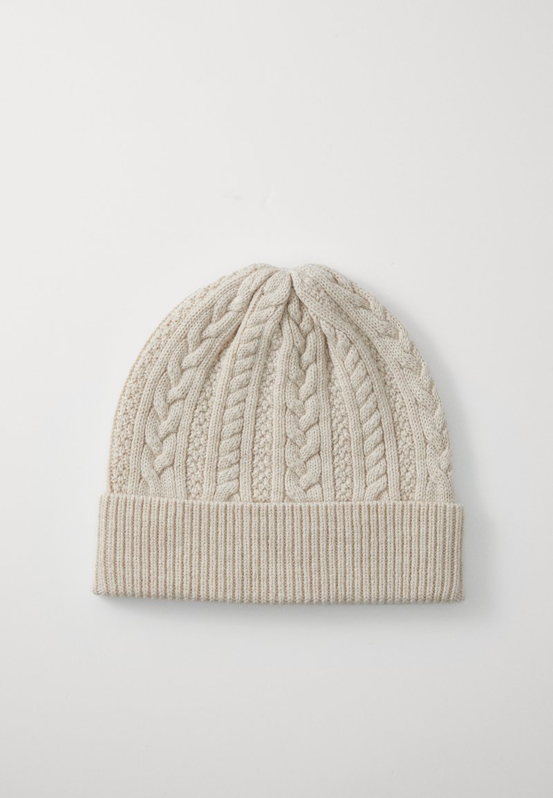 Light beige knitted beanie featuring a textured cable pattern and a ribbed cuff. The design is soft with a flexible fit.