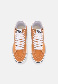 Zapatillas altas de ante naranja con cordones blancos, un parche de logo negro y costuras blancas en contraste. Forro interior liso y suela de goma.