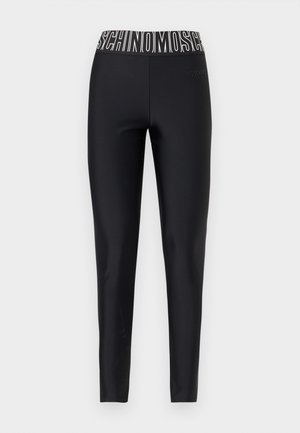 Schwarze, bodenlange Leggings mit elastischem Bund und auffälligem weißen MOSCHINO-Logo-Schriftzug.