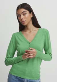 Grüner, langärmeliger Pullover mit V-Ausschnitt, geripptem Saum und drei Knöpfen am Ausschnitt. Weiche Textur, taillierte Passform. Lässiger Stil.