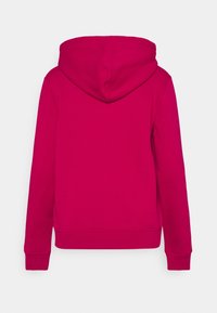 Sudadera con capucha fucsia, con textura suave, puños y dobladillo acanalados. Vista trasera muestra un diseño sin costuras, sin bolsillos ni herrajes.