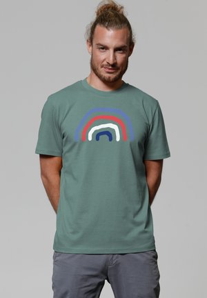 Green cotton t-shirt featuring a multicolored abstract rainbow design in red, blue, white, and dark blue on the front. Short sleeves.