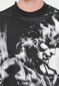 Μαύρο φούτερ με γραφικό τύπωμα κλασικού γλυπτού σε αποχρώσεις του λευκού και του γκρι. Στρογγυλή λαιμόκοψη, απαλό ύφασμα και άνετη εφαρμογή.