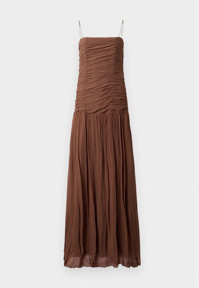 Brown maxi dress made of textured fabric. Features a ruched bodice and flowing skirt, with thin adjustable straps and a straight neckline.