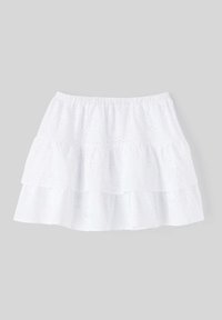 Jupe blanche à volants avec une taille élastique et une texture à motifs de broderie. Trois couches créent un effet froncé. Matière en coton douce.