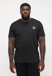 Black cotton t-shirt featuring a crew neck and short sleeves. It has a white graphic design on the chest, creating a contrast.