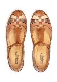 Sandalias de cuero marrón con diseño trenzado, que cuentan con acentos en un tono claro y metálico, correa ajustable y un interior acolchado.