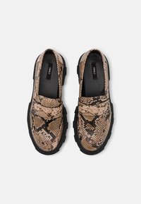 Lodjursmönstrade loafers med en texturerad, konstläderövre del. Svart gummisula. Har en slip-on design med rund t å.