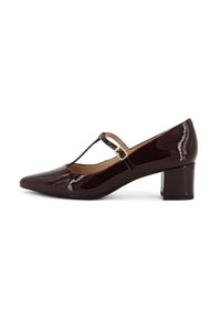 Décolleté in pelle laccata bordeaux con punta affusolata, design T-strap e tacco blocco. Presenta un accento in attacco dorato sulla cinghia.