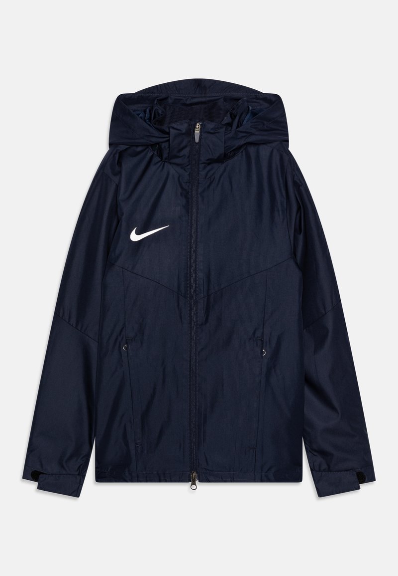 Navy blue Nike jacket with a hood, full zipper, two front pockets, and white logo on the left side. Smooth, lightweight, and water-resistant fabric.