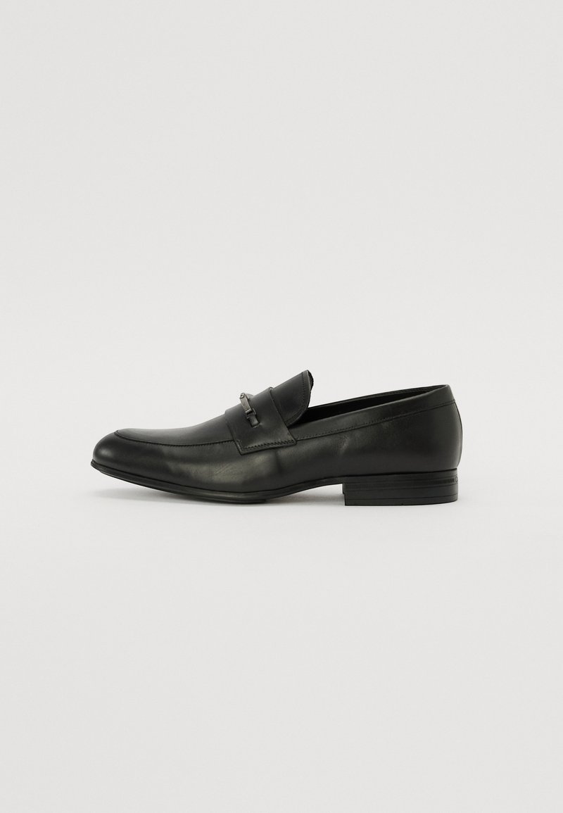 Mocasini din piele neagră, cu vârf rotund, design slip-on, cu un mic accent metalic în față și un toc scăzut, din straturi.
