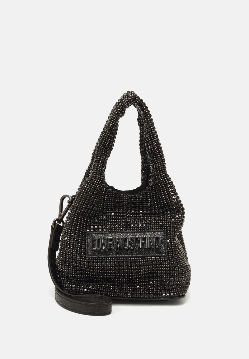 Fekete gyöngyökkel díszített táska, laza kialakítással, kiemelkedő logópaddal és levehető válltartóval. A felülete fényes és tükröződő.