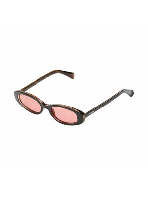 Lunettes de soleil ovales fines en écaille de tortue avec des verres teintés rose et des branches noires fines, inclinées sur fond blanc.