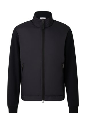 Zwarte jas met hoge kraag, dubbele rits aan de voorkant en ritssluitingen aan de zijkanten, lange mouwen en geribbelde manchetten.